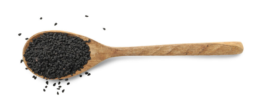 Black cumin seeds in spoon isolated on white, top view