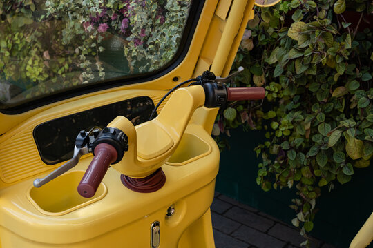 Bright yellow auto rickshaw interior with handlebars