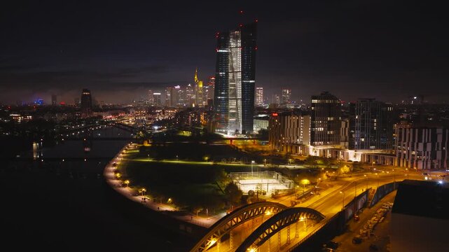 Aerial view of the ECB at night, with the bridge arches and the skyline creating a captivating urban landscape, Frankfurt am Main, Hessen, Germany.