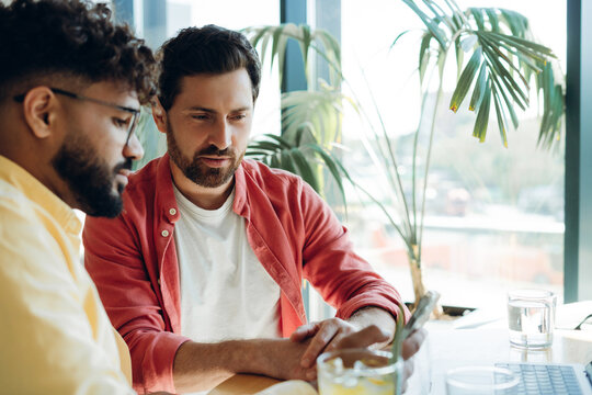 Confident team, businessmen holding mobile phone text message, chatting - Powered by Adobe