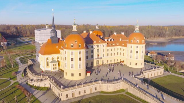 Aerial view of Moritzburg Castle in Moritzburg, sunlit and framed by autumn scenery, water areas, and a clear wide landscape.