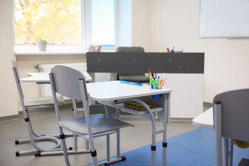 Stylish classroom with desks and chairs at school