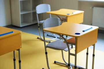 Classroom with yellow desks and chairs at school