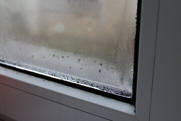 Condensation forms on window glass during cold winter morning in a cozy indoor setting