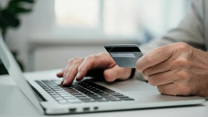 Man using laptop and holding credit card for online shopping or payment - Powered by Adobe