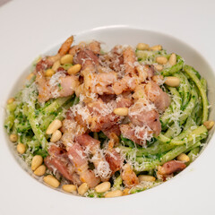 Recipe for linguine pasta with spinach pesto, smoked bacon, and Parmesan cheese. High quality photo