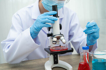 Scientist medical professional use microscope for research in science laboratory.