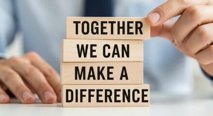 Together We Can Make A Difference: A person meticulously places wooden blocks, crafting an inspiring message of unity and collaborative impact.