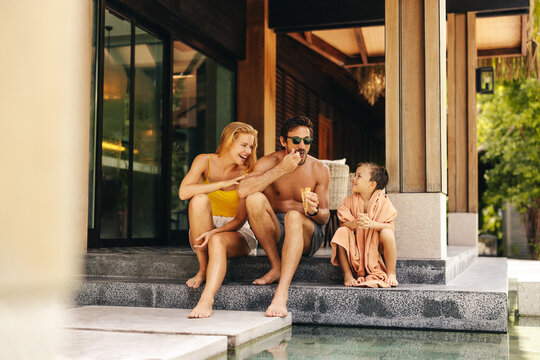 Happy parents and son enjoy ice cream at luxury villa