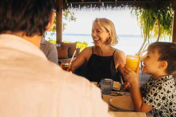 Joyful family enjoying a luxurious dining experience at a tropical resort with ocean views