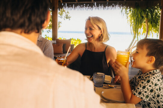 Joyful family enjoying a luxurious dining experience at a tropical resort with ocean views