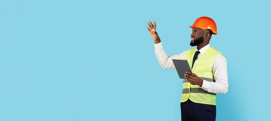 Black Male Construction Engineer With Hand Showing Copy Space Over Blue Studio Background, Smiling Black Builder Man Holding Clipboard And Demonstrating Free Place For Advertisement, Panorama