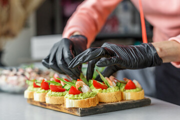 Chef Preparing Shrimp Avocado Canapés with Tomato and Greens