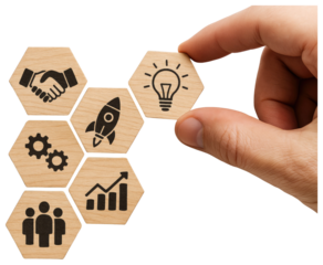 Hand placing lightbulb hexagon tile onto arrangement of business concept icons on wooden hexagons idea isolated on a transparent background