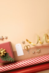 Christmas gift wrapping with red and white striped wrapping paper, ribbon, scissors, cedar spruce on beige backdrop. Copy space.