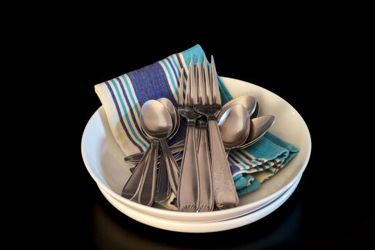 couverts de table avec cuill&egrave;res, fourchettes , assiettes, et serviette sur fond noir