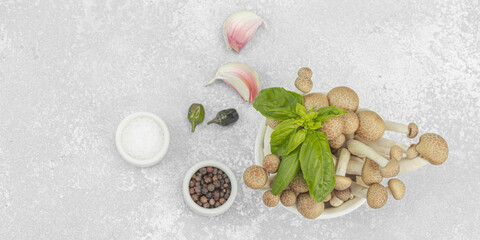 Fresh assorted shimeji mushrooms with olive oil, basil, garlic, salt, pepper on rustic background