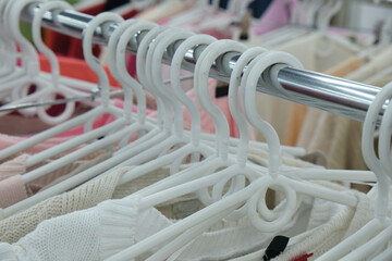 A diverse selection of women's clothing is neatly displayed on hangers in a stylish boutique, highlighting retail selection and contemporary fashion.