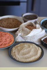 Bowls and bags full of various healthy grains and legumes. Selective focus.