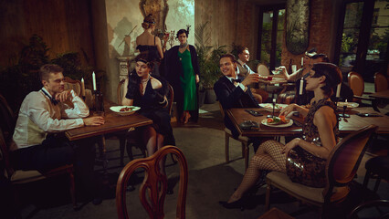 Retro dinner gathering with elegant friends celebrating in warm vintage atmosphere. Concept of holiday nightlife visuals, restaurant promos, retro events, fashion storytelling with joyful emotion.