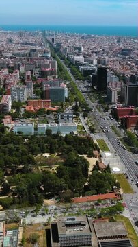4K aerial vertical video of Barcelona skyline featuring Avinguda Diagonal leading to the sea. Drone footage of urban traffic, parks, and city architecture. Cinematic Spain travel background for mobile