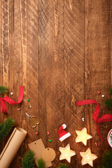 Christmas wrapping background with star candles, wrapping paper, fir spruces, gift tags on wooden desk. Copy space for text or design.
