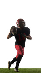 American football player jumping with triumphant emotion holding ball isolated on white background. Concept of victory, sport celebration, athlete branding, promotional use.