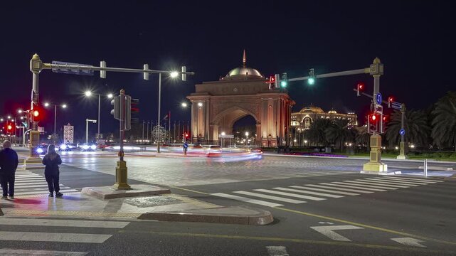 night time illuminated abu dhabi city famous palace hotel entrance traffic street crossroad panorama timelapse 4k united arab emirates  