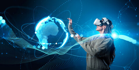 Woman wearing VR headset interacting with glowing digital Earth, futuristic tech wave graphics, on a blue background. Concept of innovation and future