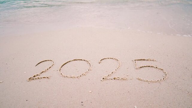 4K happy new year 2026. number 2025 write on sandy beach, ocean wave splash change to 2026. countdown for happy new year turning from year 2025 to 2026 video footage background