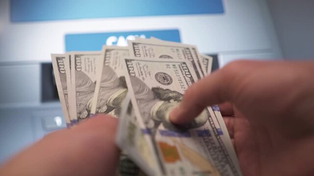 A man withdraws cash from an ATM.