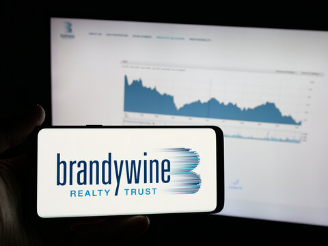 Stuttgart, Germany - 11-13-2025: Person holding smartphone with logo of real estate company Brandywine Realty Trust on screen in front of website. Focus on phone display.