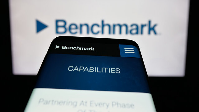 Stuttgart, Germany - 11-13-2025: Mobile phone with website of US company Benchmark Electronics Inc. on screen in front of logo. Focus on top-left of phone display.