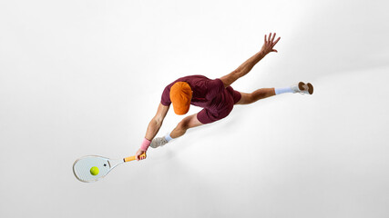 Athletic tennis player stretching sideways for return shot in dynamic overhead view. Concept of psychology of movement, concentration training, resilience, and focus visualization.