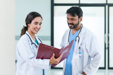 male and female doctors in white medical uniforms discuss patient anamnesis together. team brainstorming make decision concept.