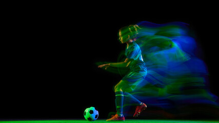 Female football player dribbling ball in cyan and green light motion. Concept of skill development, training visuals, body in motion, and commercial sport campaigns.
