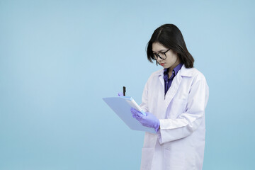 An Asian female scientist or doctor in a lab coat, diligently writing on a clipboard for data...