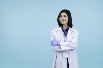 Smiling Asian female scientist or doctor in a lab coat, standing confidently with crossed arms,...