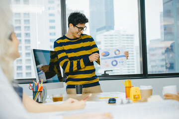 Young male professional smiles confidently while presenting busi