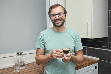 Man making coffee with coffee machine in modern kitchen. Person preparing espresso at home and enjoying a fresh cup of coffee. Concept of morning routine, home comfort, and caffeine energy