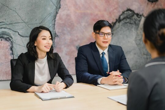 Smiling executive panel conducting professional job interview or client consultation and assessment in a corporate meeting - Powered by Adobe