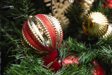 Christmas tree with red ball and lights garland. Xmas and New Year card. Winter. Outdoors. Close up.
