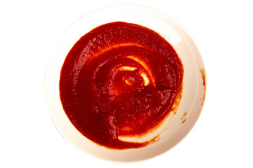 Ketchup splashing on a white plate on white background