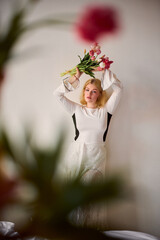Blondehaired woman delicately balancing tulips with dreamy