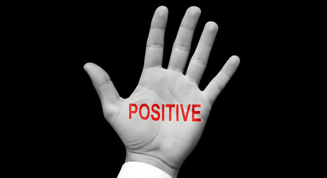 Hand with the word positive in red against a black background symbolizing optimism and encouragement for motivational content and positive affirmations and inspirational messages