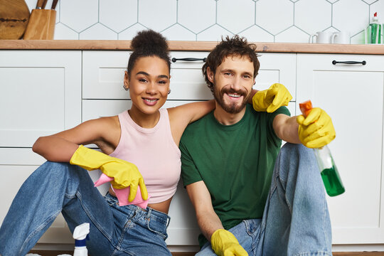 Young couple enjoying cozy home cleaning together, sharing smiles and fun moments