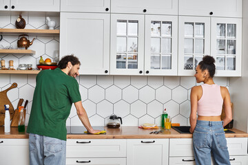Cozy moment shared in the kitchen as a young couple enjoys household chores together