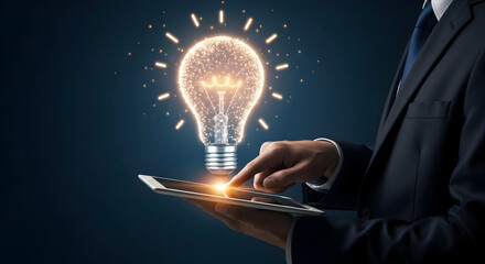 Businessman using tablet with glowing lightbulb representing innovation and ideas in a dark blue background symbolizing creativity technology and modern business solutions for success