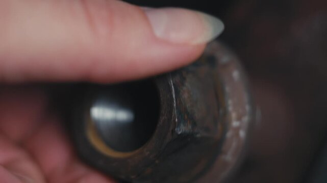 Hand Holding Rusted Nut Close Up with Soft Light