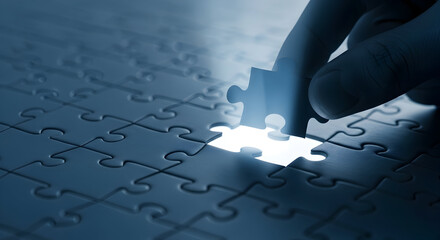 Hand places the final jigsaw puzzle piece into a completed puzzle symbolizing problemsolving strategy and achieving goals in business education and personal development projects
